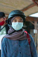 portrait of asian muslim woman wearing sports helmet and mask