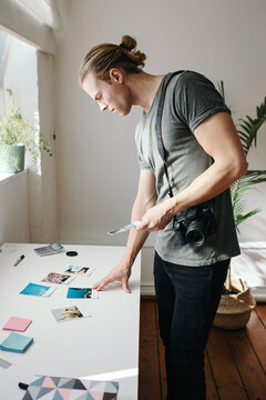 Male photographer reviewing prints in his studio