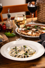 Seafood and cheese ravioli with creamy sauce and fresh basil