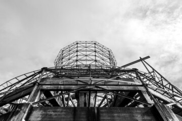 Up view of abandoned dismantled cooling tower with a cloudy sky, in monochrome.