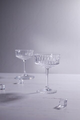 Two empty glasses for champagne on white and grey background - copy space