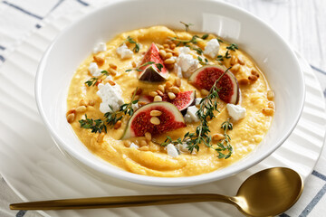 Pumpkin soup with feta, figs, pine nuts, top view