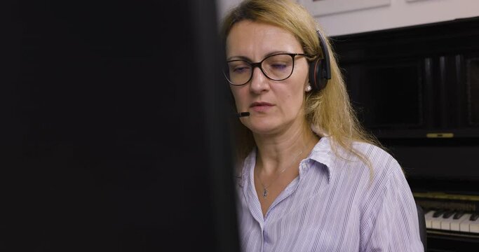 Schock nach Blackout im Home-Office wegen Covid. Mitarbeiterin k&auml;mpft mit Shock und bespricht am Telefon vor dem Computer.