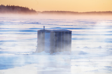 Ice Fishing hut on a frozen harbour in the mist. - 464096457