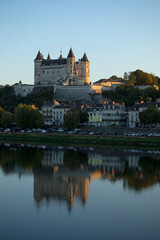 Château sur les bords de la Loire dominant la vieille ville de Saumur. Quai de bord de fleuve un soir d'été au soleil couchant.