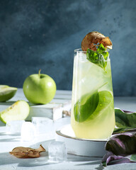Drinks and cocktails. Cool alcoholic cocktail with apple, basil and ice on a light background. Tropical concept. Sunlight. Background image, copy space