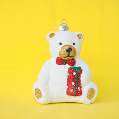 Christmas tree toy cute white teddy bear on a yellow background..