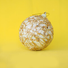 golden Christmas ball on a bright yellow background..