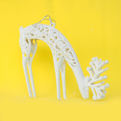 Christmas tree toy white shiny deer on a bright yellow background..