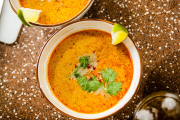 Asian hot red soup in a clay bowl on the table