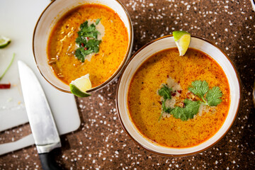 Asian hot red soup in a clay bowl on the table