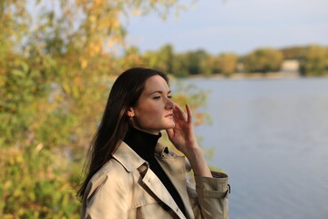 Brunette woman in a coat outside in autumn