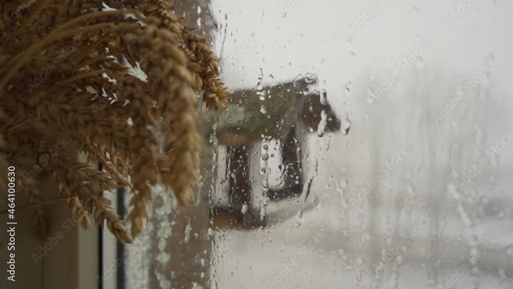 Wall mural heavy snowfall behind the window. slow motion. raindrops running down a window.