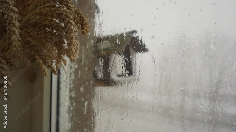 Wall mural heavy snowfall behind the window. slow motion. raindrops running down a window.