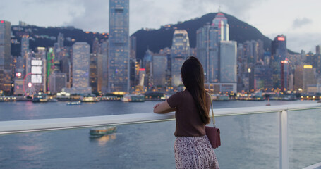Fototapeta na wymiar Woman wear face mask and look at the city of Hong Kong