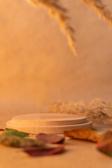 Round wooden podium for food or cosmetics on warm yellow kraft paper background. Plate for perfume...