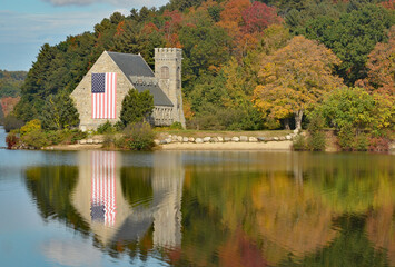 Fototapeta na wymiar American flag on the Old Stone Church with an autumnal background