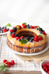 Ciambella decorata con frutti di bosco e menta e con una glassa di limone 