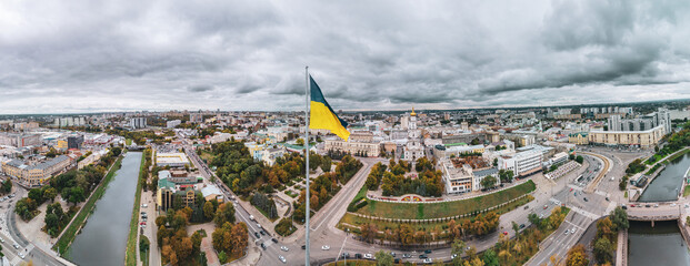 Tallest flag of Ukraine with epic gray cloudscape, wide city aerial panorama landscape on autumn...