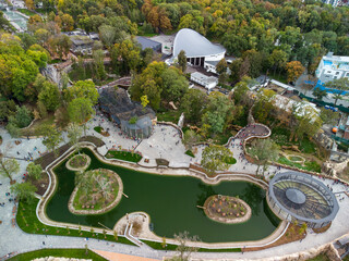 Autumn city aerial look down view on Kharkiv zoo lake surrounded by greenery and walking paths....