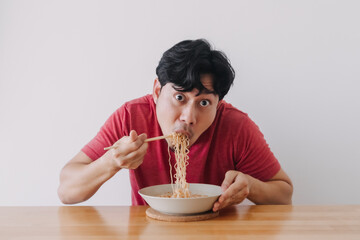 Asian man eat instant noodle very deliciously.