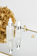 Two glass white cosmetic jars with pipettes dispensers. Dry inflorescences of Buldenezh. mirror...