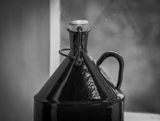 The old bottle against window in black and white