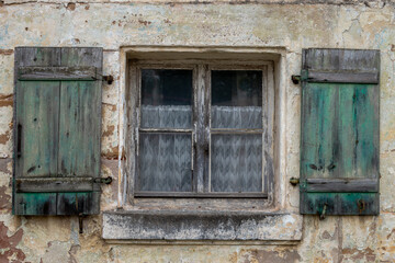 Fototapeta na wymiar A window from an old half-timbered house with green shutters