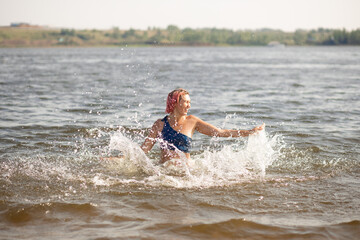 A young woman swims in the river