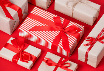 Gift boxes in craft paper on a red background.
