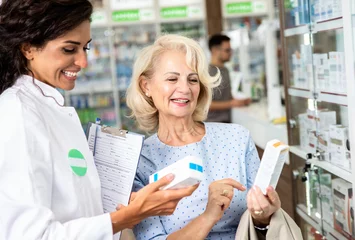 Foto op Plexiglas Apotheker die medicijnen verkoopt aan senior vrouwelijke klant in de apotheekwinkel. © Zoran Zeremski