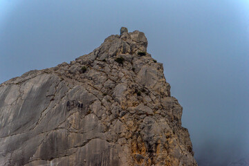 Fototapeta premium Stony slopes of mountain in dense fog.