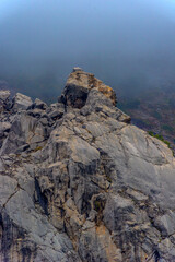 Fototapeta premium Stony slopes of mountain in dense fog.