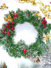 Fototapeta na wymiar Christmas frame with space for text. New Year's decor: wreath, garland, tinsel, spruce with berries, bows, beads. The concept of a festive mood.