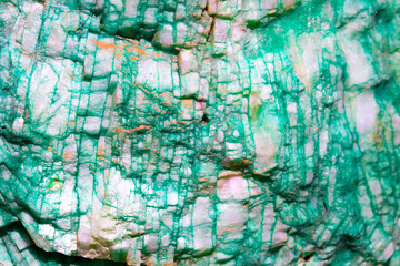 Fototapeta na wymiar Background from dracocene crystals of stones. Fluorite stone in the rocks of the adit. Mineral stones in their natural environment. Semiprecious stones texture.