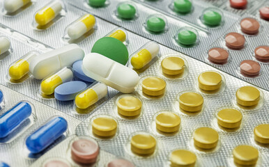 Heap of medical pills in white, blue and other colors.  Concept of healthcare and medicine.