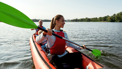 European family floats on canoe boat in lake