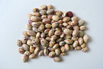 A pile of seeds of colorful dragon tongue beans, white background