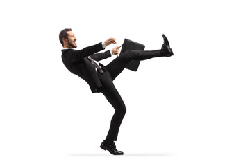 Full length profile shot of a businessman doing a silly walk