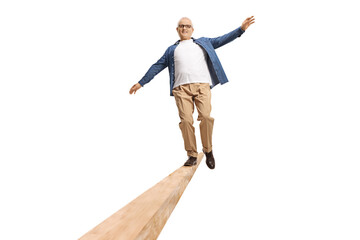 Full length portrait of a mature man walking on a wooden beam
