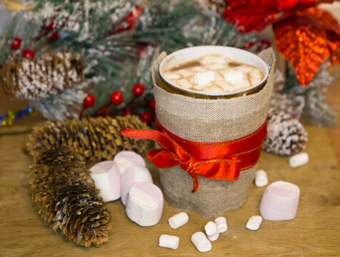 Enamel Cup Of Hot Cocoa With Mini Marshmallows And Candy Canes With Pine Boughs And Cones