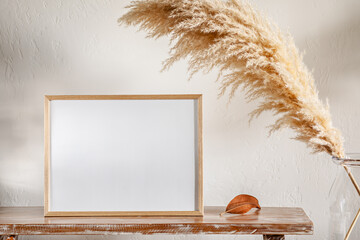 30x40 cm photo frame on a bench with pampas grass near the wall