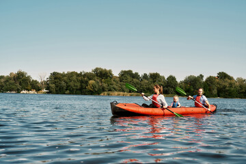 Caucasian family floats on kayak in lake or river