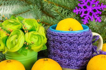 Tangerines, flowers and a mug.