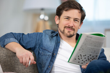 young man doing a crossword puzzle