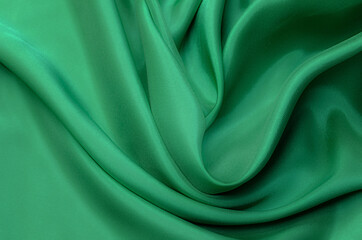 Close-up texture of natural green or emerald fabric or cloth in same color. Fabric texture of...