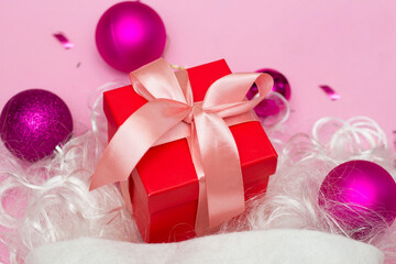 Christmas composition. A Christmas red hat made of fireworks made of balls, sequins, ribbons on a pink background. Flat layout, top view, place to copy.