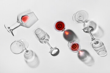 Glasses with leftover red wine on light background
