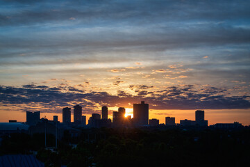 Fototapeta na wymiar Sunrise over city silhouette with golden and blue sky