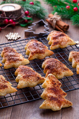 Christmas puff pastry cookies with sugar and cinnamon on a cooling rack, vertical
